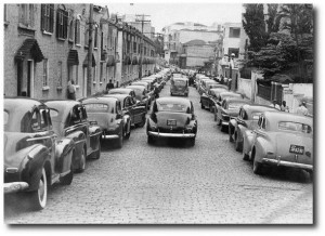 Brasil, São Paulo, SP, 19/01/1963. Vista de vários taxis estacionados na Rua Taguá, em São Paulo, enquanto os motoristas participam de assembleia para deliberar sobre o aumento das tarifas em face da majoração do peço da gasolina. Pasta: 46.190